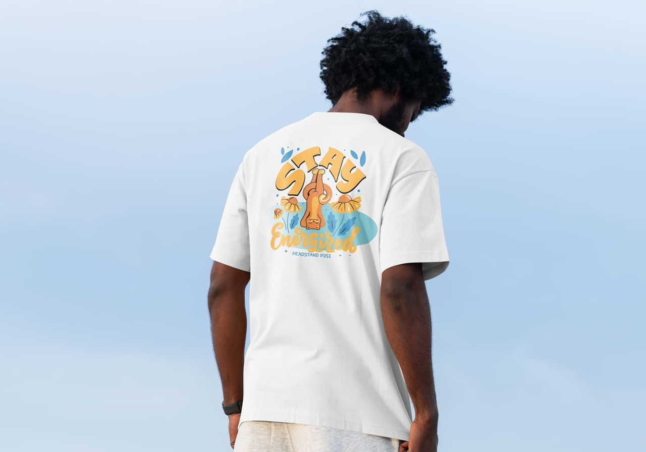 A person wearing a white t-shirt with a colorful graphic design on the back, standing outdoors against a blue sky.