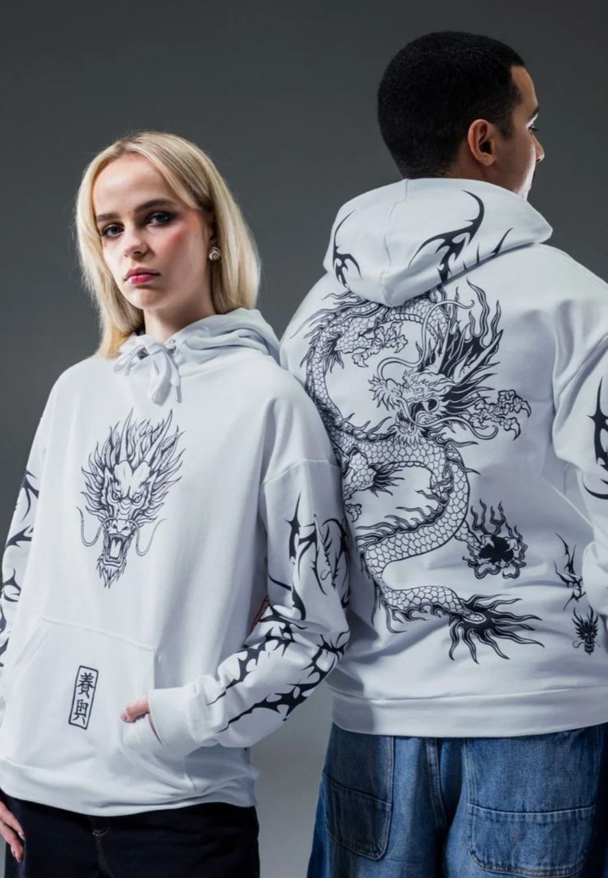 a man and woman wearing white hoodies with dragon designs