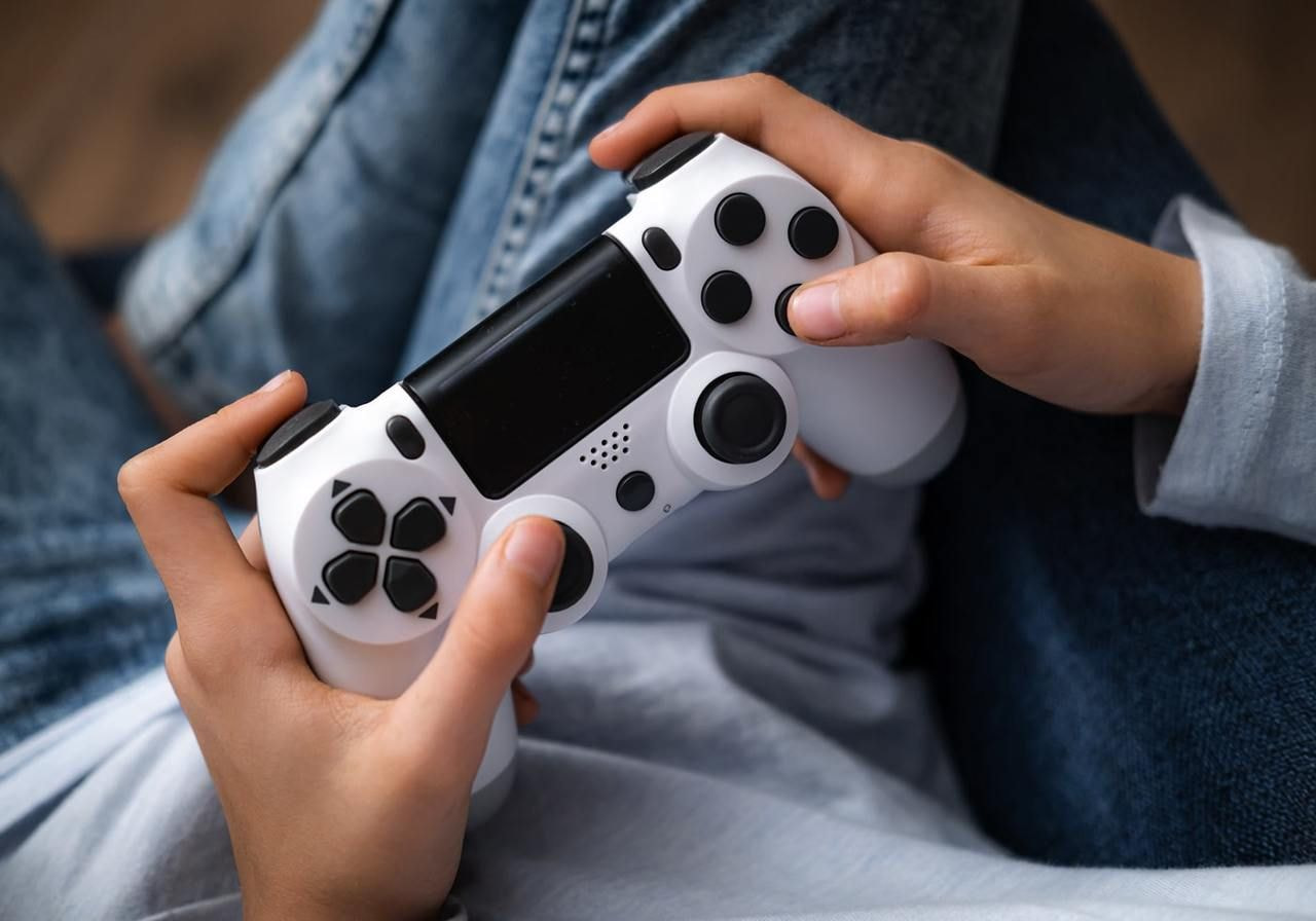 A person is holding a game console controller.