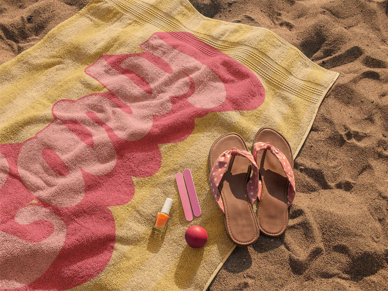 a towel and sandals on sand