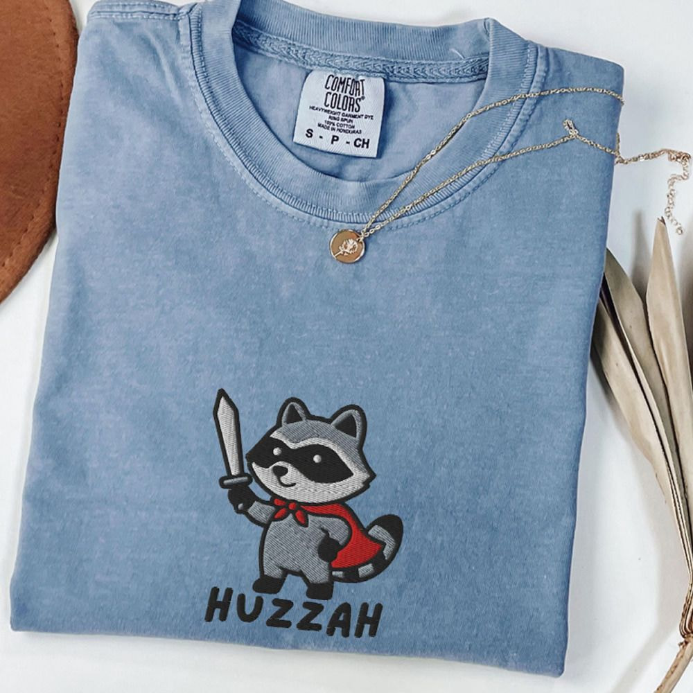 A shirt featuring a raccoon graphic paired with a stylish hat, showcasing a playful and casual outfit.