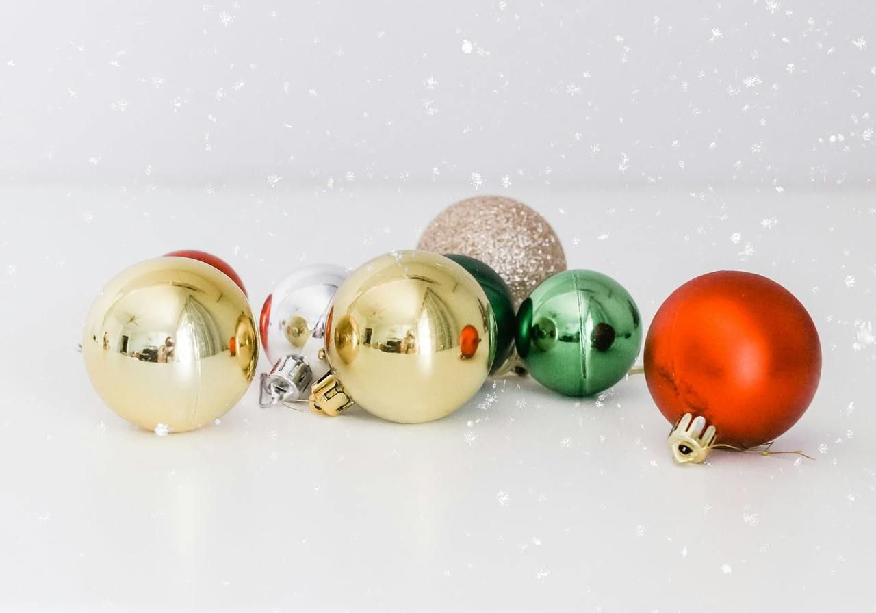 Colorful Christmas ornaments arranged on a white background, showcasing various shapes and designs.