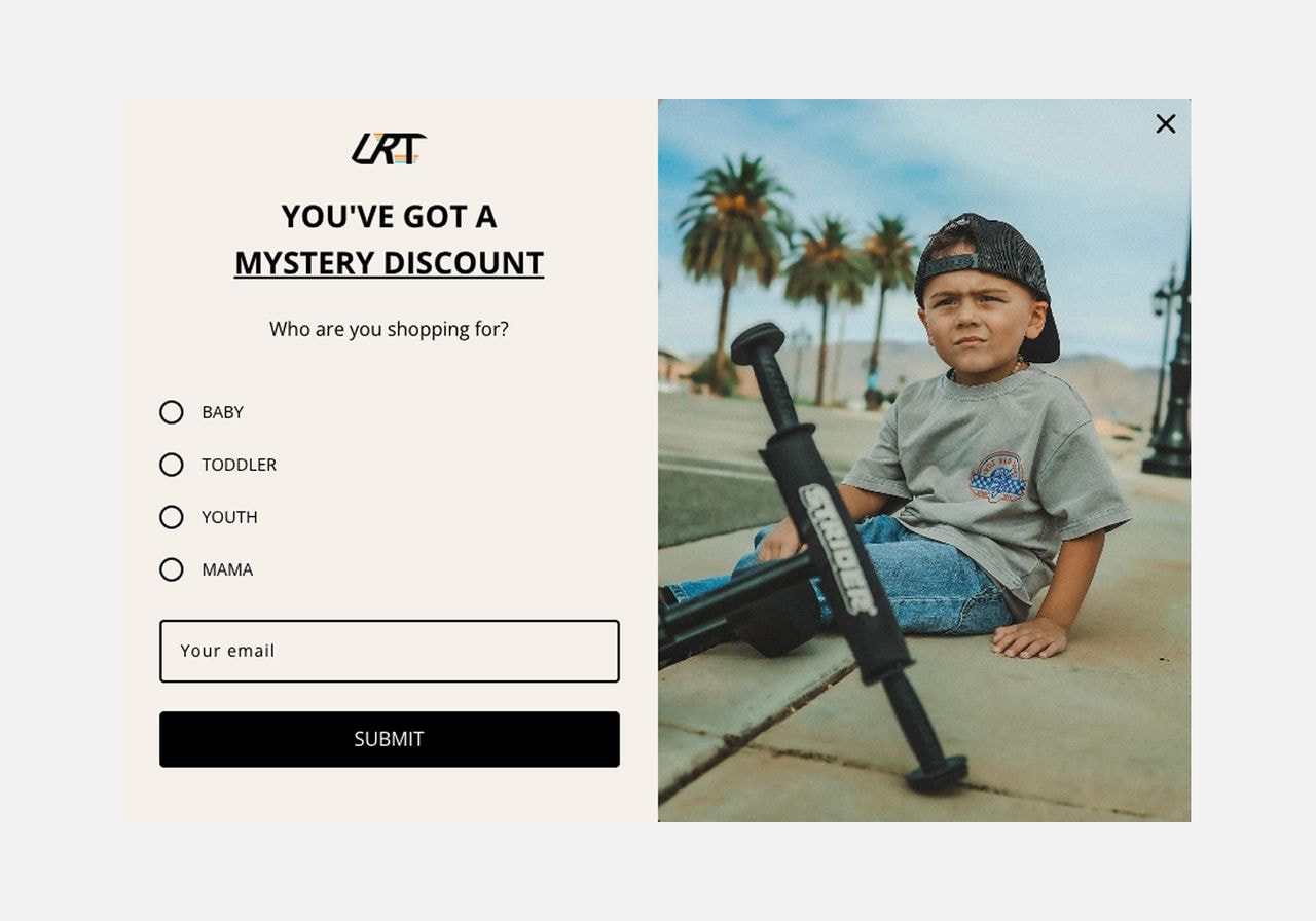 Screenshot of a kids' clothing website popup offering a mystery discount with a photo of a boy sitting beside a scooter.