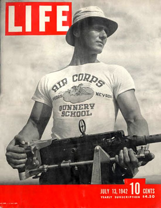 Black and white Life magazine cover featuring a man in a "Gunnery School" t-shirt holding a machine gun.