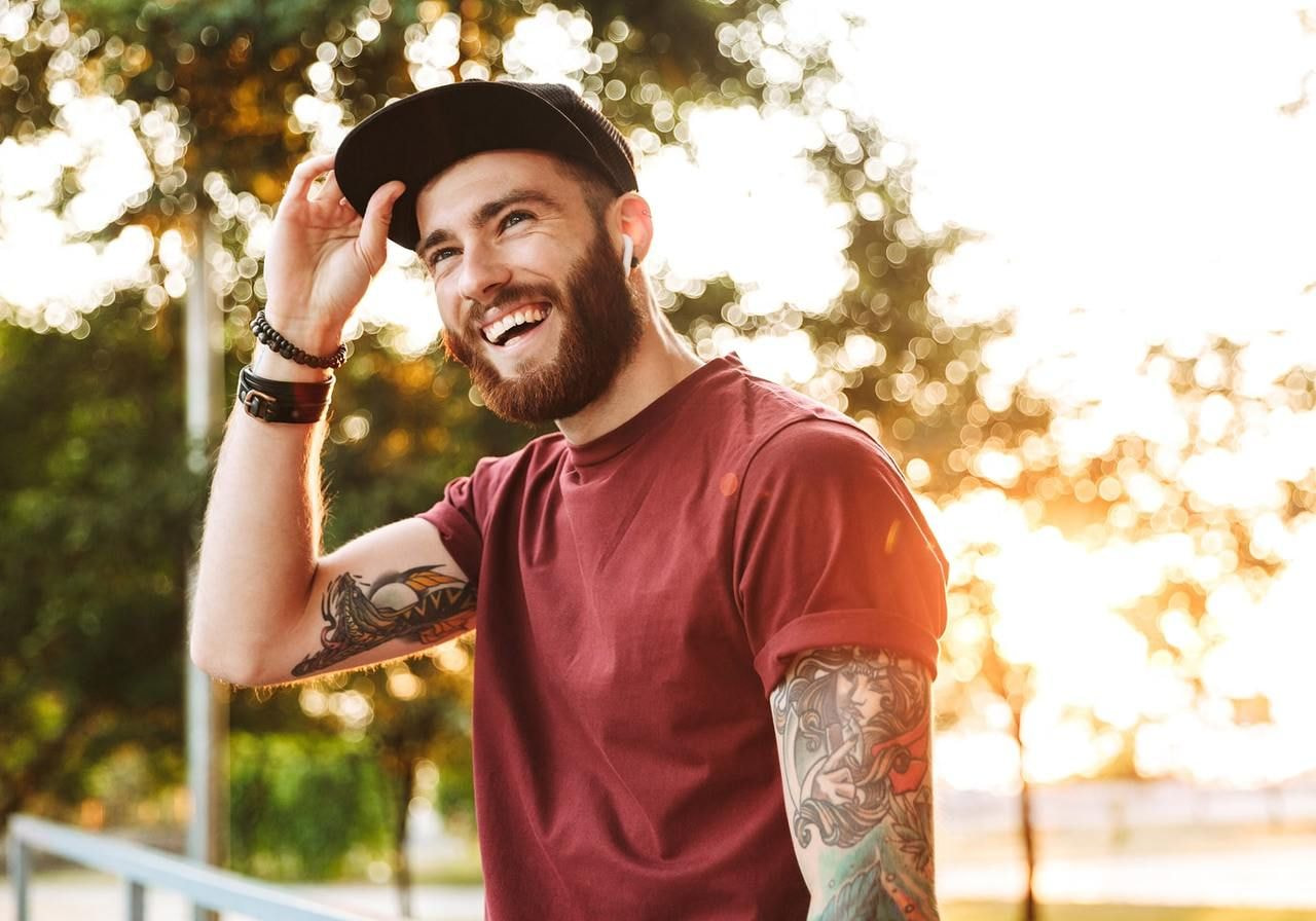 A smiling man wearing a black 6-panel hat.