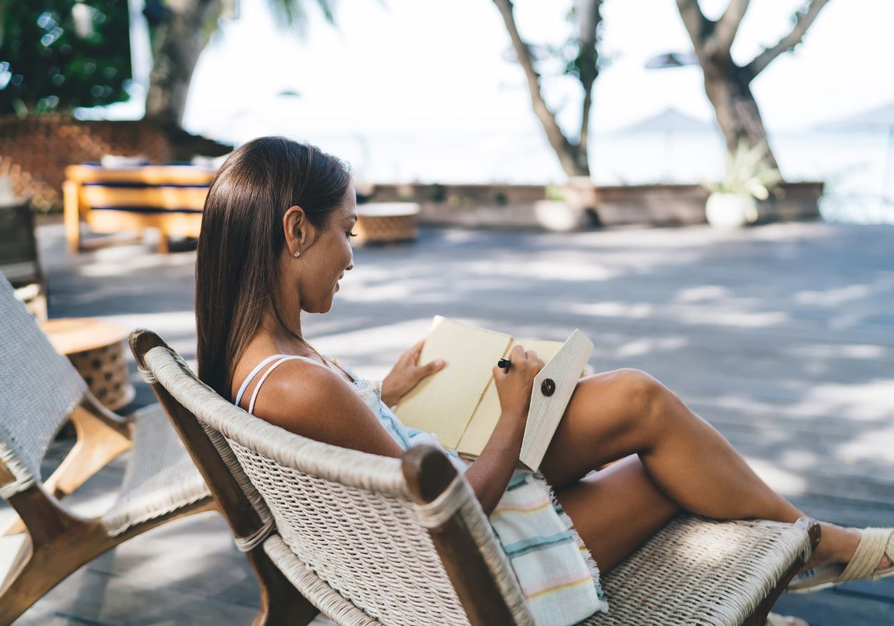 A woman is journaling outside.