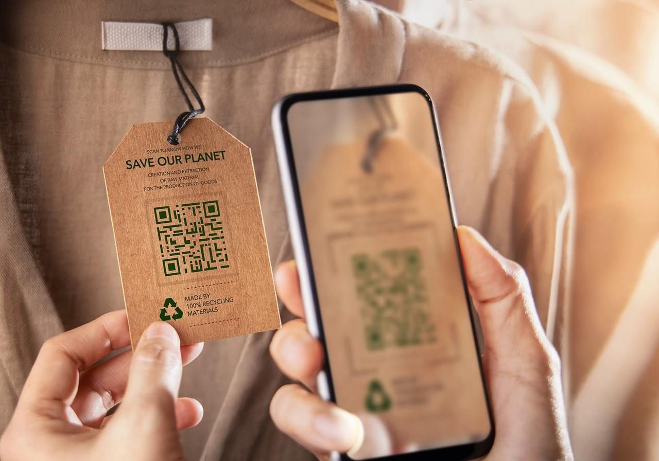 A person is taking a picture of a product tag stating that the product is sustainable.