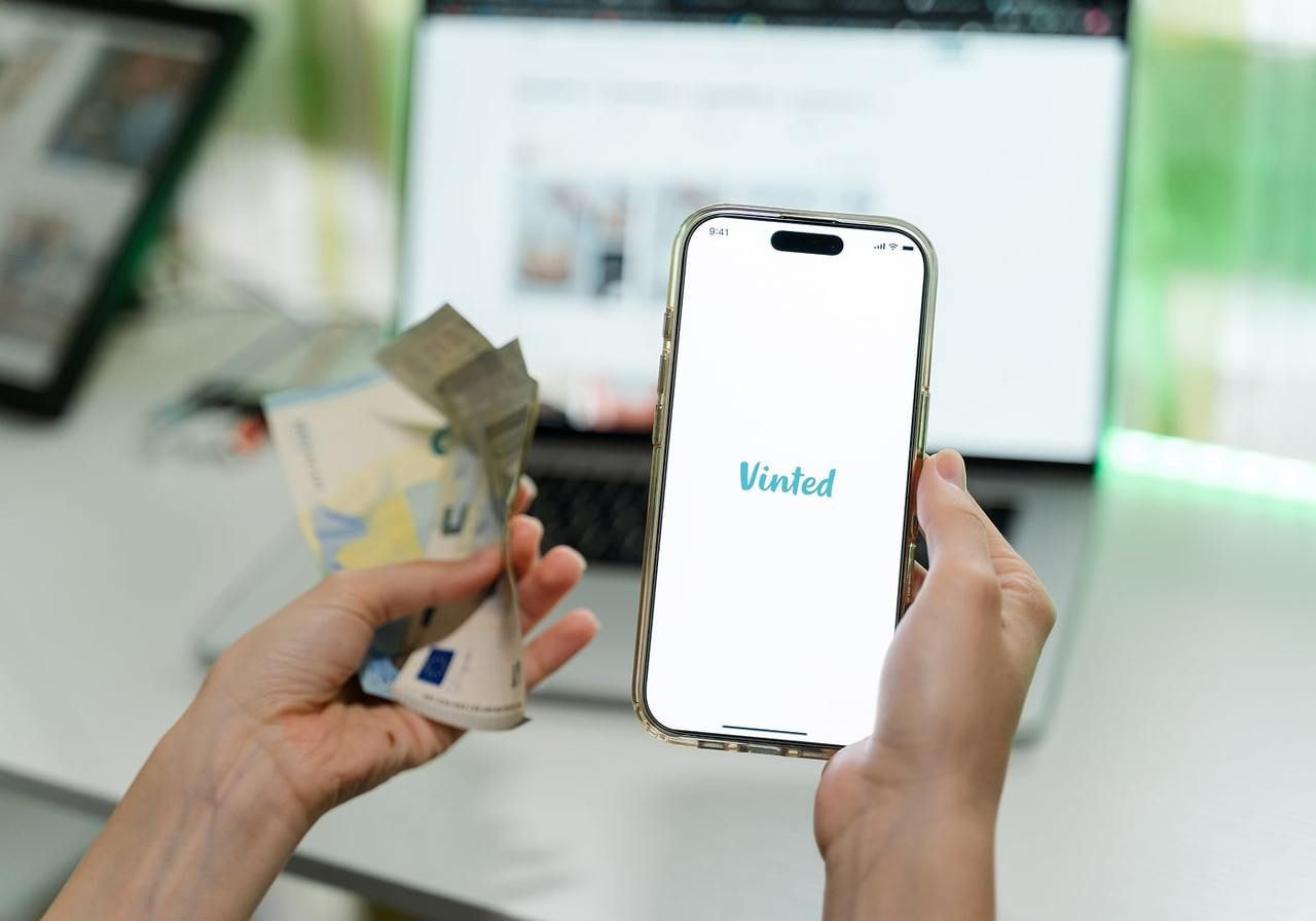Person holding a phone with Vinted application on.