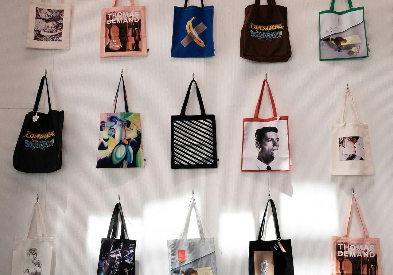 A wall displaying numerous bags of various styles and colors hanging neatly.