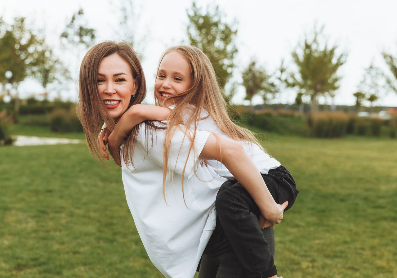 A woman and a girl in t-shirts outside