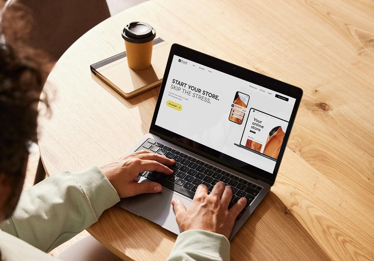 A person is using a laptop with Ecwid’s homepage on the screen.