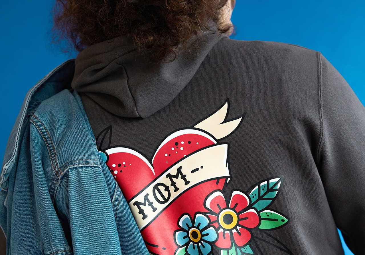 A person wearing a hoodie with a colorful heart design on the back, featuring the word