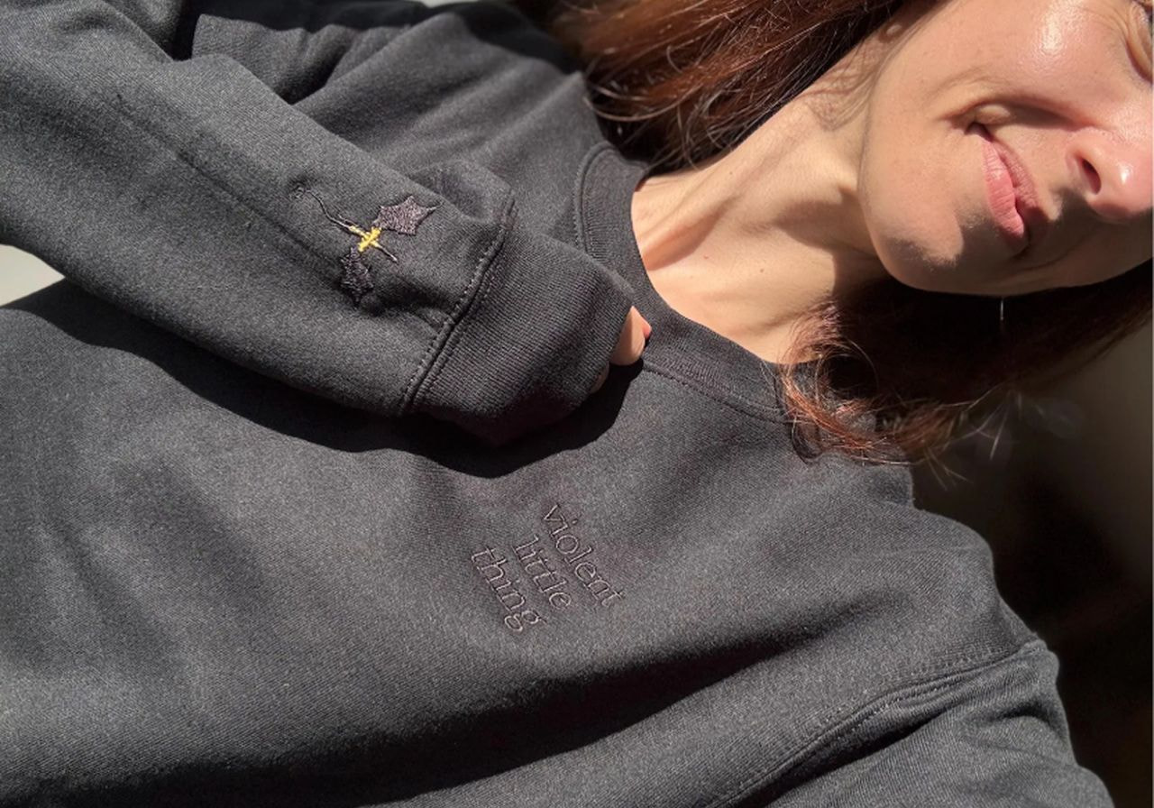 A woman in a black sweatshirt displaying the phrase "love is love," promoting inclusivity and acceptance.