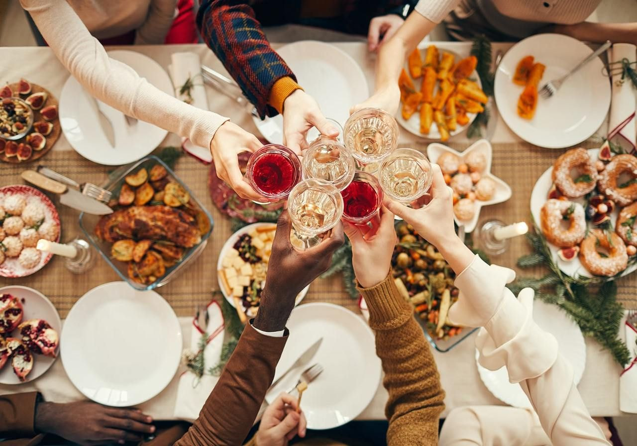 A group of people joyfully toasting with glasses at a festive dinner table, celebrating together.