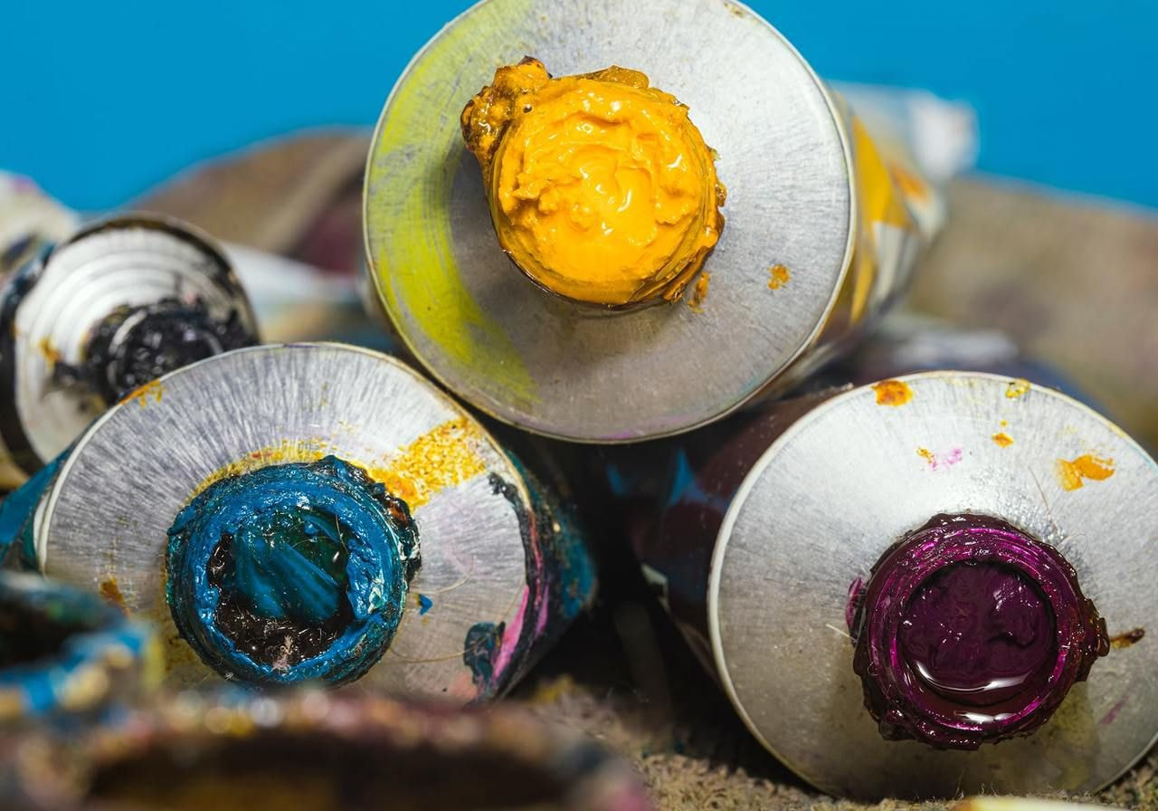 A colorful assortment of paint tubes stacked together, showcasing various hues and shades.