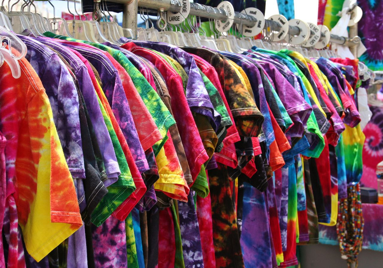 A vibrant display of colorful tie-dye T-shirts neatly arranged on hangers.