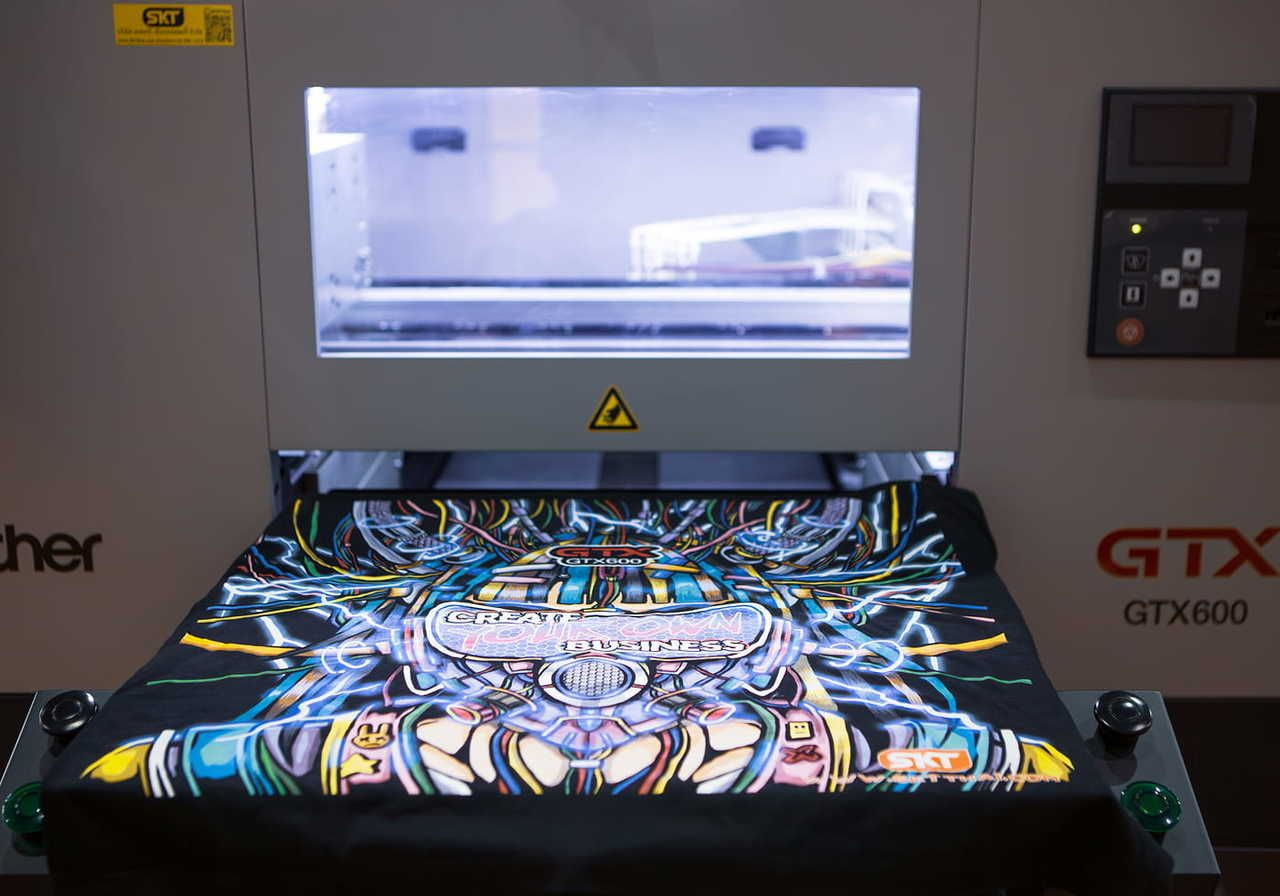 T-shirt with a colorful, intricate design on a high-tech printer. The machine's screen glows softly.