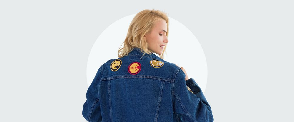 a woman wearing a denim jacket with patches on it