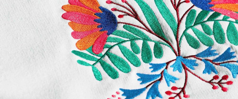 a colorful flower embroidery on a white cloth