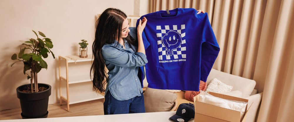 Print-on-demand product selection featuring a t-shirt, sweatshirt, and dress mockups.