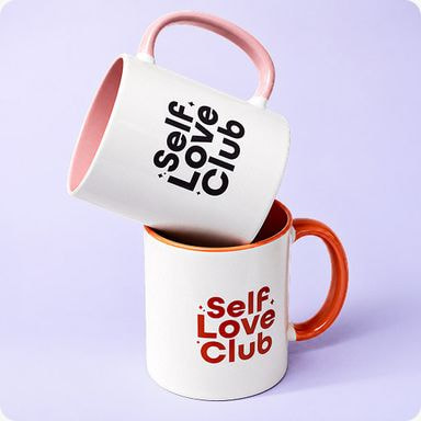 two white and orange coffee mugs