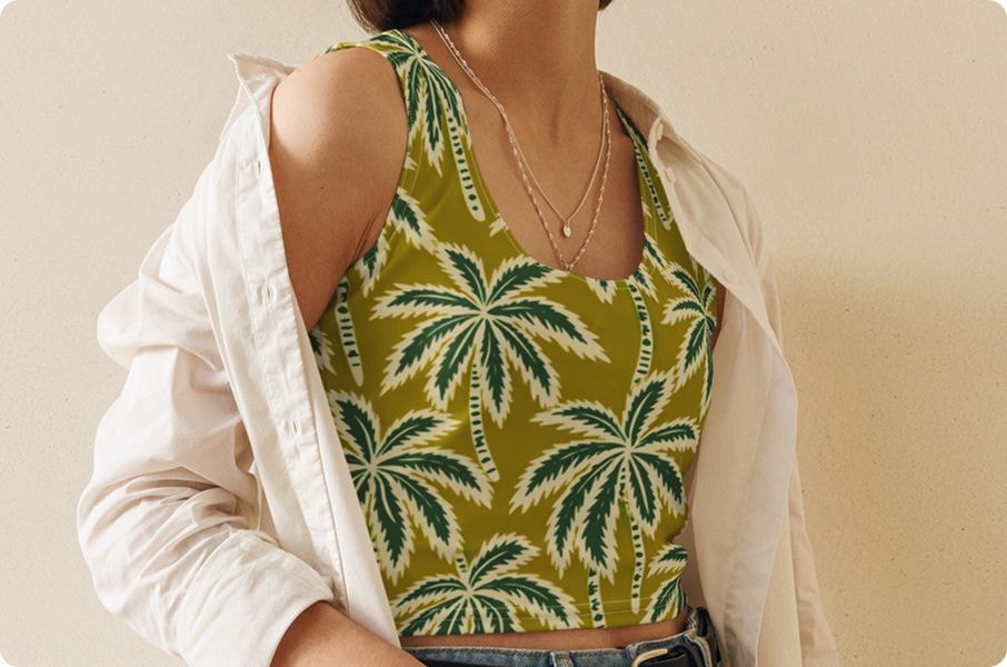 Woman wearing cropped tank top with tropical palm leaf pattern and open shirt.