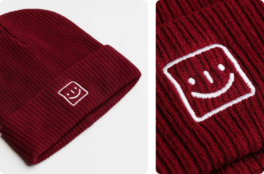 a red beanie with a smiley face on it