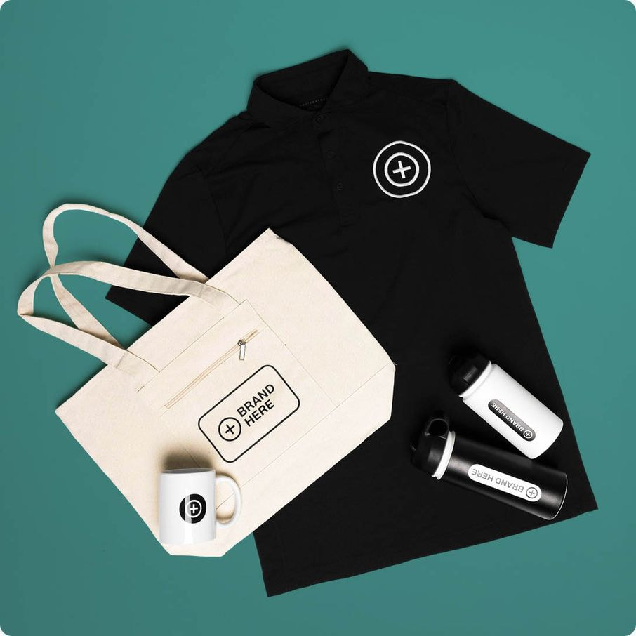 Flat lay of a black polo shirt, canvas tote bag, mug, and two water bottles, all printed with a circular brand logo and Brand Here placeholder text.