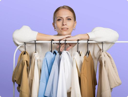 a woman leaning on a rack of clothes