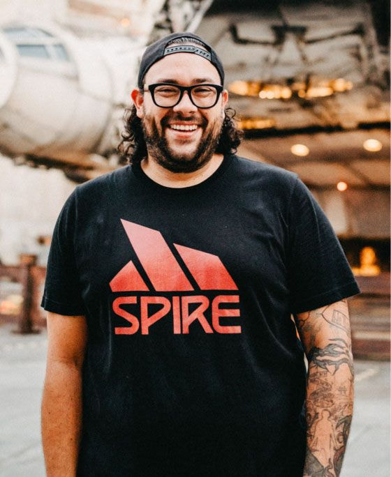 man smiling wearing a t-shirt with a logo