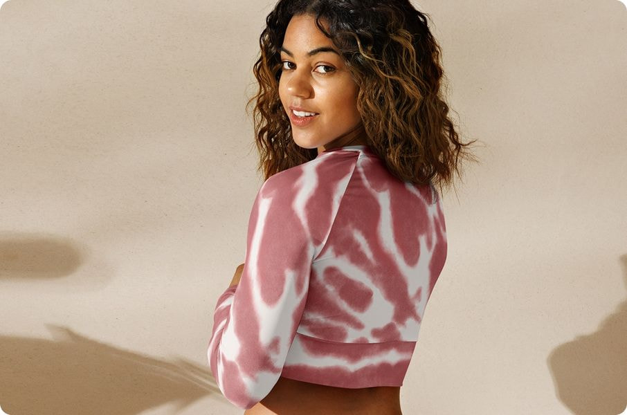 Woman wearing pink tie-dye cropped sweatshirt designed for active movement and comfort.