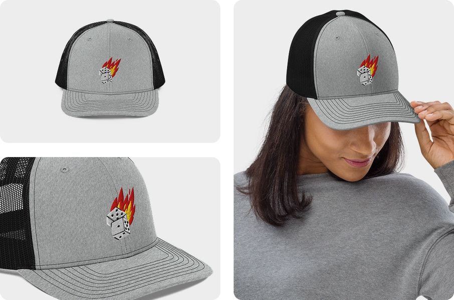 A grey and black mesh trucker hat featuring a flaming dice embroidery logo, shown in detailed close-up shots and on a model to highlight the quality of the custom design.