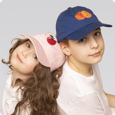 two kids, a boy and a girl, wearing colorful hats