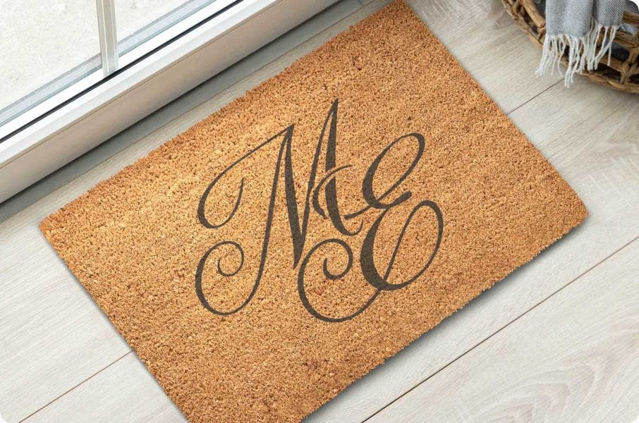 Custom coir doormat displaying an elegant scripted monogram, ideal for personalized home décor and gifts.